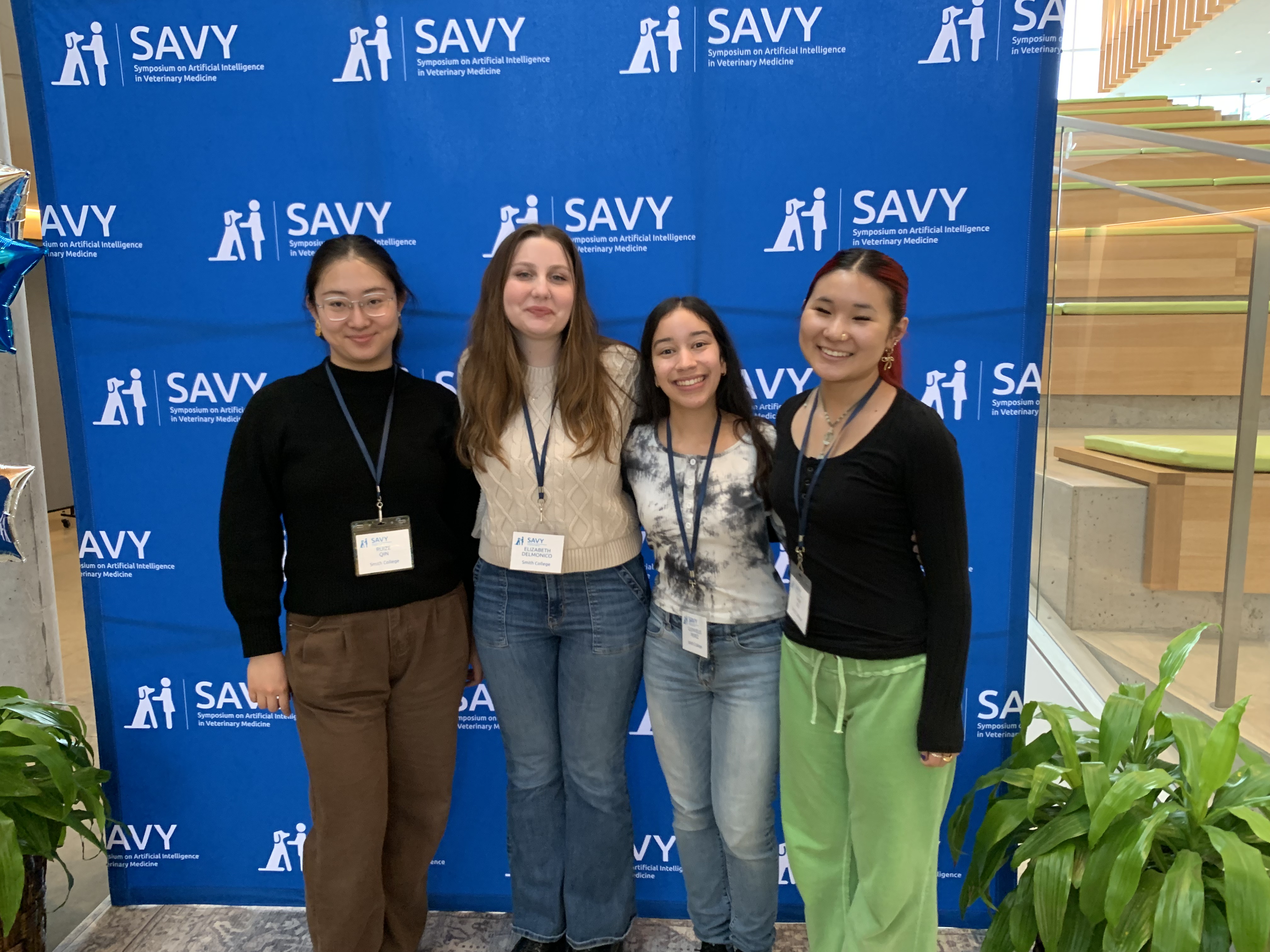 The students posing in front of the SAVY banner